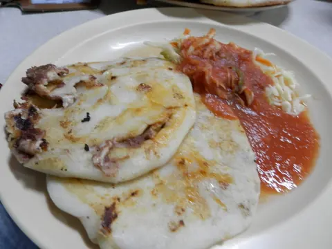 Pupusas served with curtido and salsa